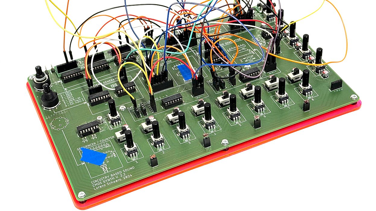 Green circuit board with multiple integrated circuits, knobs, buttons, and colorful patch cables connecting various components
