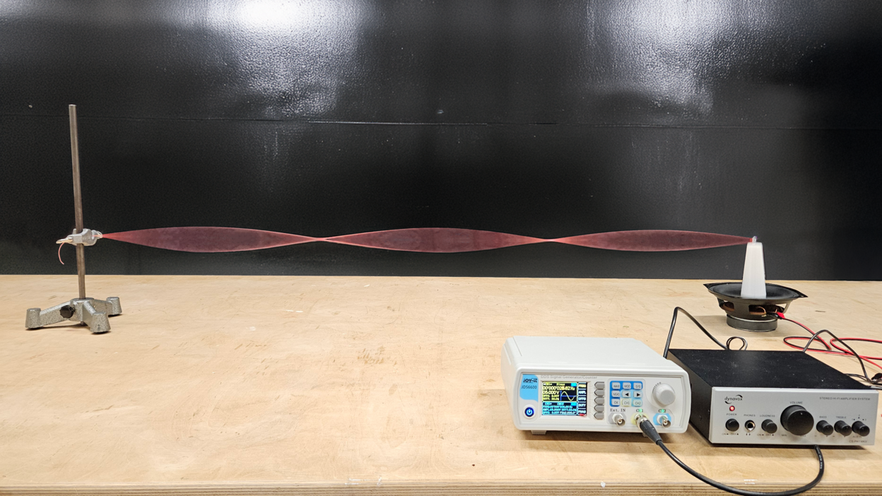 Demonstration of standing waves on a string excited by a loudspeaker, with function generator and amplifier visible